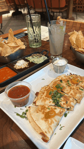a quesadilla on a plate with salsa and sour cream on it