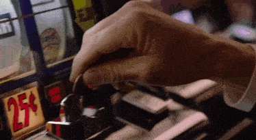 a person is putting a coin into a slot machine that has a price of 275 dollars