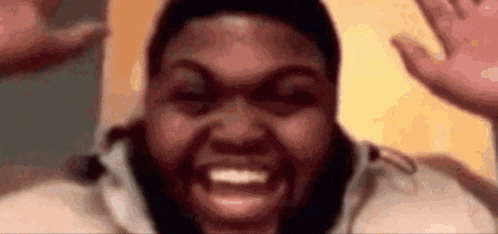 a close up of a man with a beard making a funny face and waving his hands .