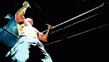a man in a wrestling ring is holding a gun in his hand