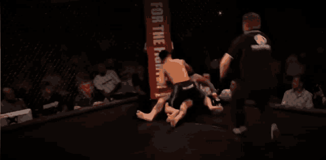 a boxing match with a sign that says for the people in the background