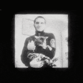 a black and white photo of a man holding a cat in his arms