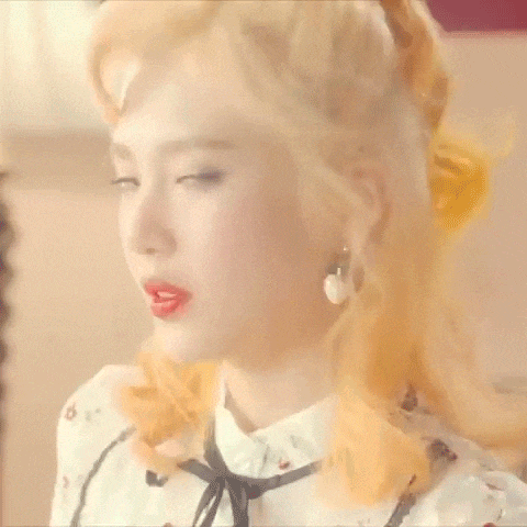 a close up of a girl with blonde hair and red lips .