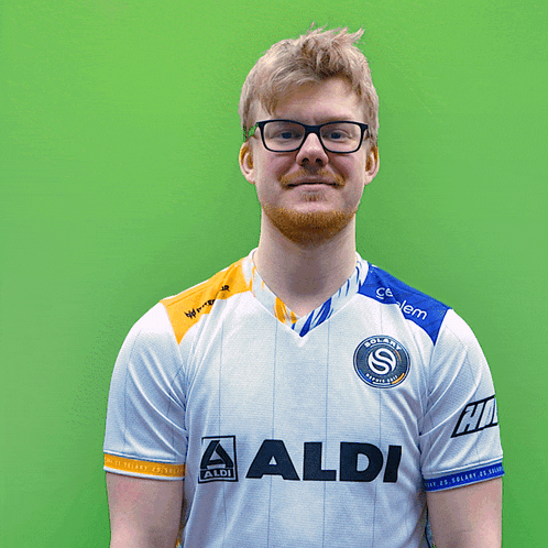 a man wearing glasses and a white shirt with the word aldi on it