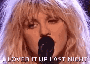 a close up of a woman singing into a microphone .