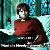 a man in a red sweater is sitting on a couch and talking to another man .