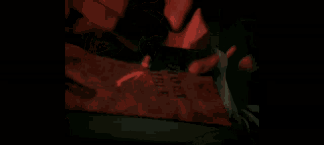 a close up of a person 's face in a dark room with red and green lights .