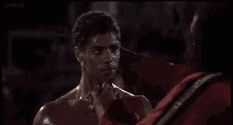 a man without a shirt is standing next to another man in a boxing ring .