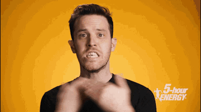a man is making a face in front of a 5 hour energy ad