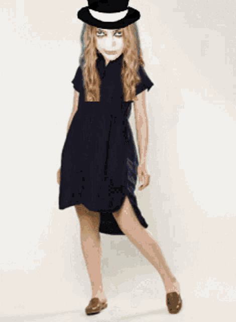 a woman in a black dress and top hat