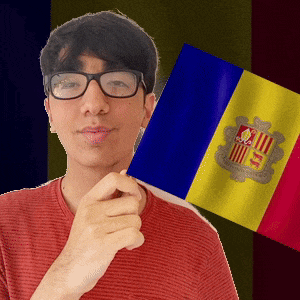 a man wearing glasses is holding a spanish flag in front of him