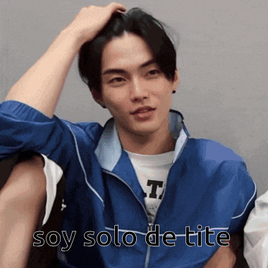 a man in a blue jacket has his hand in his hair and the words soy solo de tite written below him