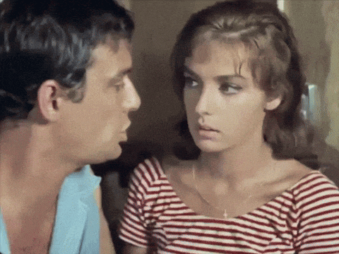 a man and a woman are looking at each other and the woman is wearing a red and white striped shirt