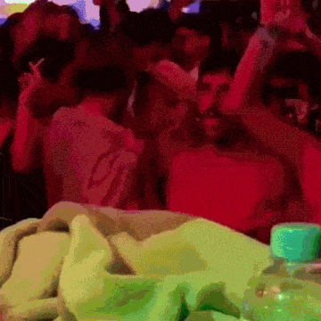 a bottle of water sits on a table in front of a crowd at a party