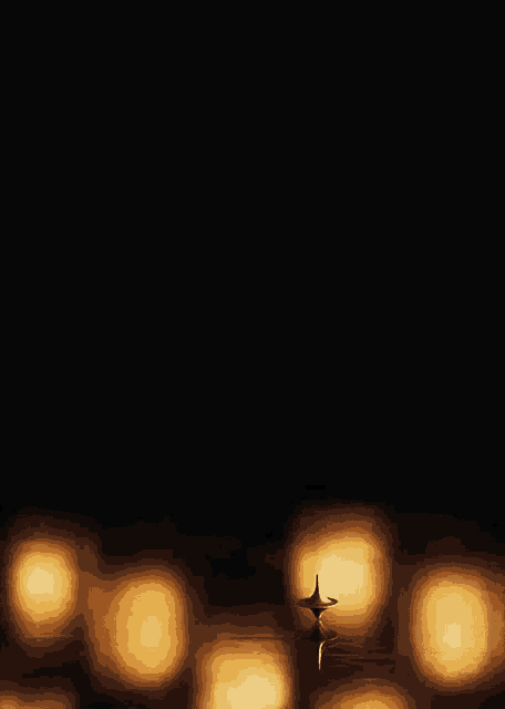 a spinning top is in the middle of a row of candles