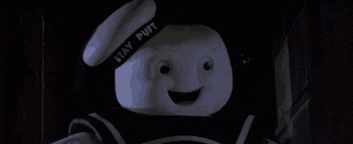a close up of a marshmallow man wearing a sailor hat and smiling .