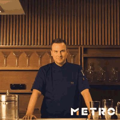 a man in a chef 's uniform is making a funny face with his eyes closed .