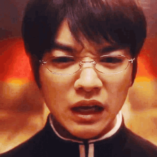 a close up of a man wearing glasses and a black jacket .