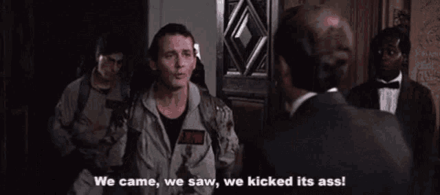 a man in a ghostbusters uniform is standing in front of a door and yelling .
