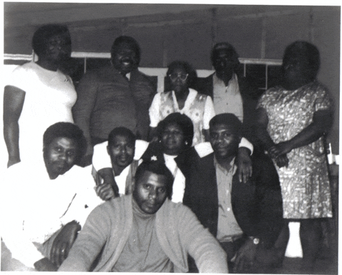a black and white photo of a group of people posing for the camera