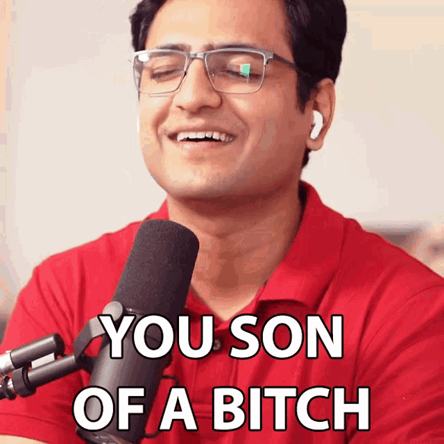 a man wearing glasses and a red shirt says you son of a bitch in front of a microphone