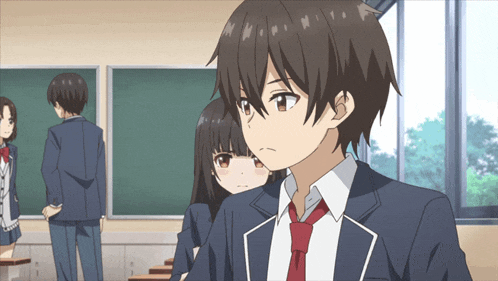 a boy in a blue suit and red tie stands in a classroom