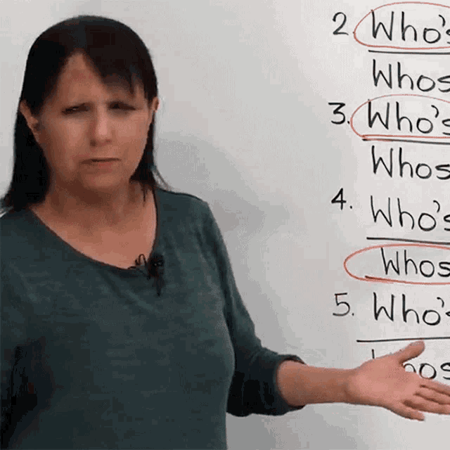 a woman stands in front of a whiteboard with the number 2 circled