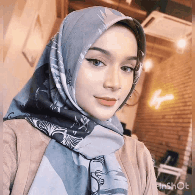 a woman wearing a hijab is taking a picture