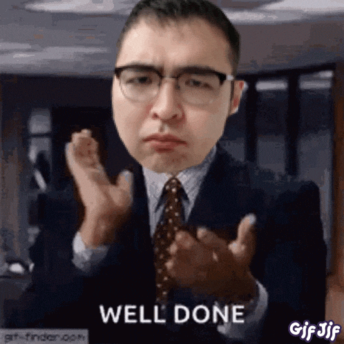 a man in a suit and tie is clapping his hands with the words well done behind him .