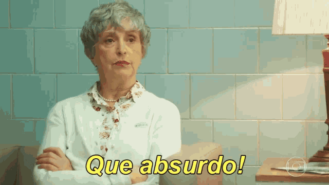 an elderly woman sitting on a couch with que absurdo written in yellow letters