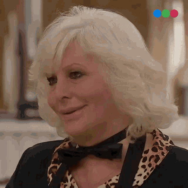a woman wearing a leopard print shirt and a bow tie