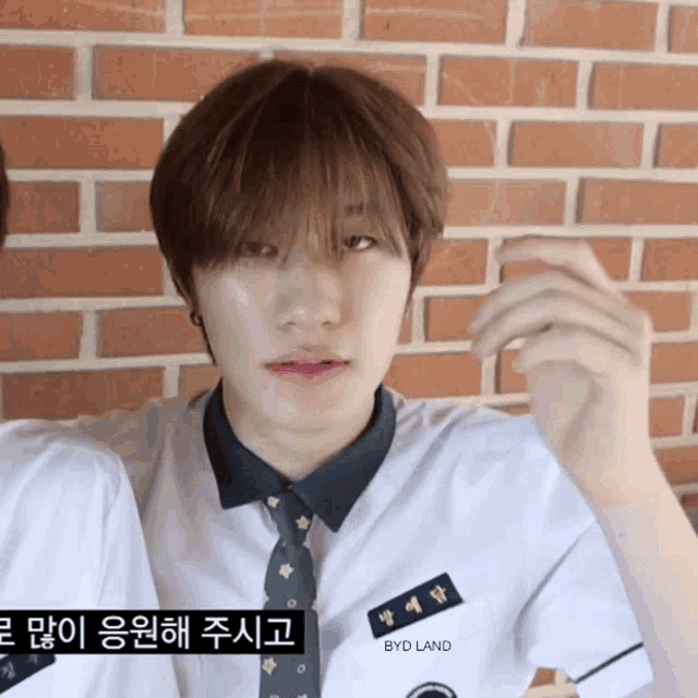 a boy in a school uniform has a name tag that says byd land on it