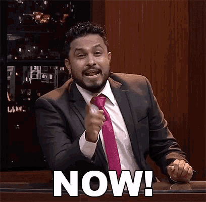 a man in a suit and tie says " now "