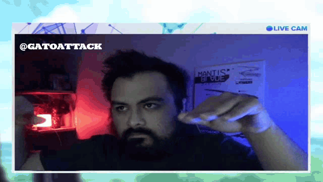 a man with a beard is giving a thumbs up in front of a poster that says mantis blue