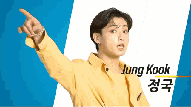 a young man in a yellow shirt is pointing his finger at something