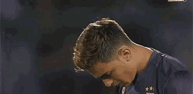 a close up of a soccer player 's face in a purple shirt .