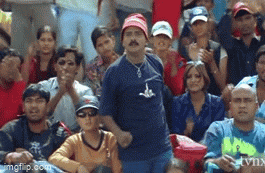 a man in a blue shirt is dancing in front of a crowd