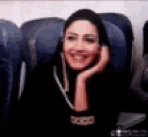 a woman is sitting on a plane talking on a cell phone