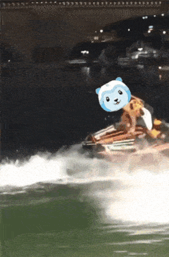 a person riding a jet ski in the water with a blue and white bear on their head