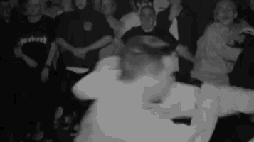 a group of people are dancing in a dark room .