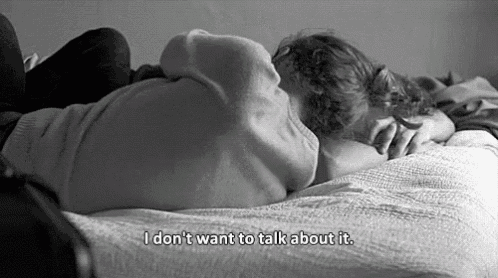 a black and white photo of a couple laying on a bed with the words `` i don t want to talk about it '' .