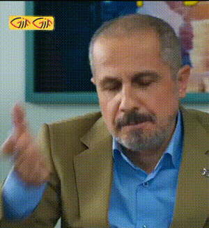 a man in a suit and blue shirt is making a funny face in front of a sign that says gifgif