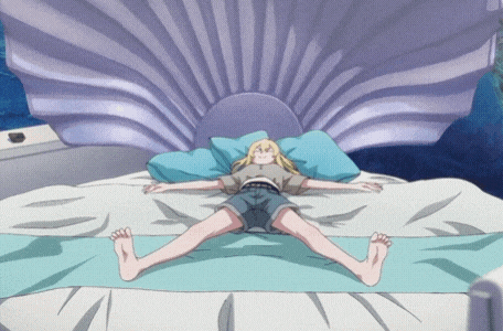 a blonde girl is laying on a bed with her legs outstretched