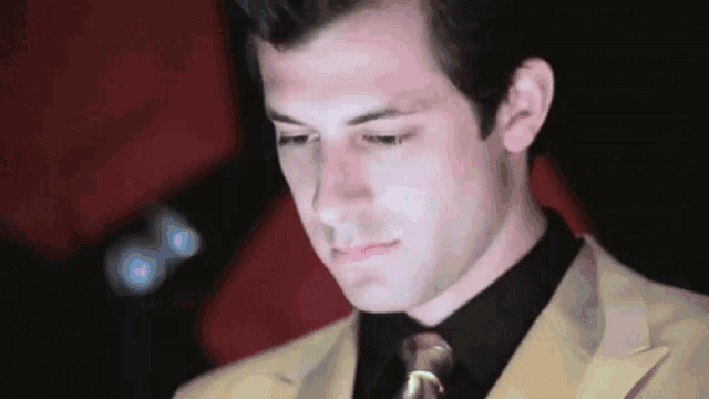 a man in a suit and tie looks down
