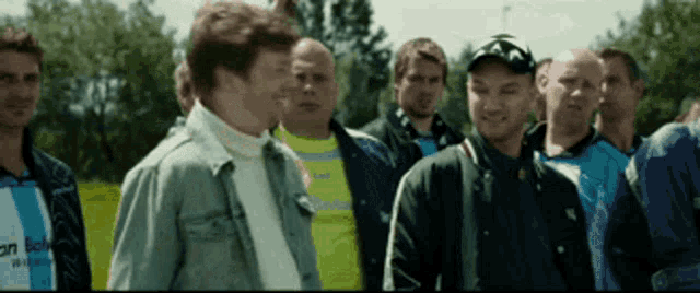 a group of men are standing next to each other and one of them is wearing a shirt that says ' salomon '
