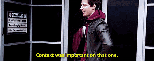 a man in a leather jacket is standing in front of a building with the words context was important on that one .