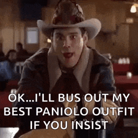 a man wearing a cowboy hat and gloves is sitting at a table in a restaurant and talking .