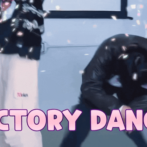 a man in a black jacket is kneeling down in front of a sign that says victory dance