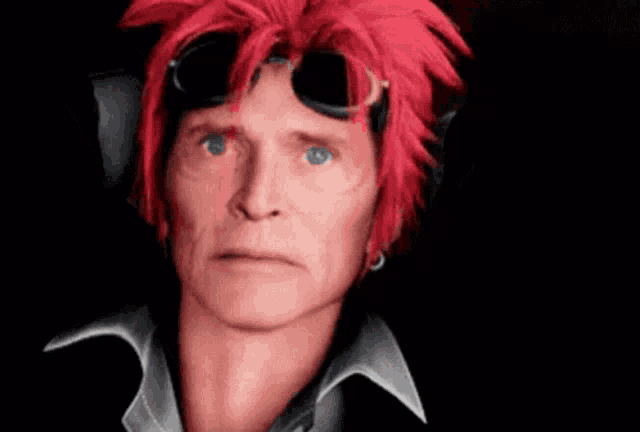 a man with red hair and goggles is making a funny face .