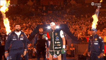 a man in a green shirt with the number 11 on it stands in front of a crowd